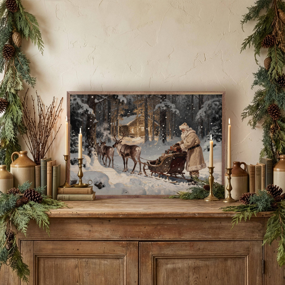 Framed vintage Santa sleigh reindeer cabin print displayed on rustic wood sideboard with holiday greenery