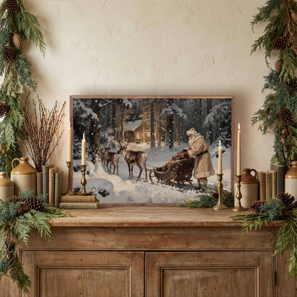 Framed vintage Santa sleigh reindeer cabin print displayed on rustic wood sideboard with holiday greenery