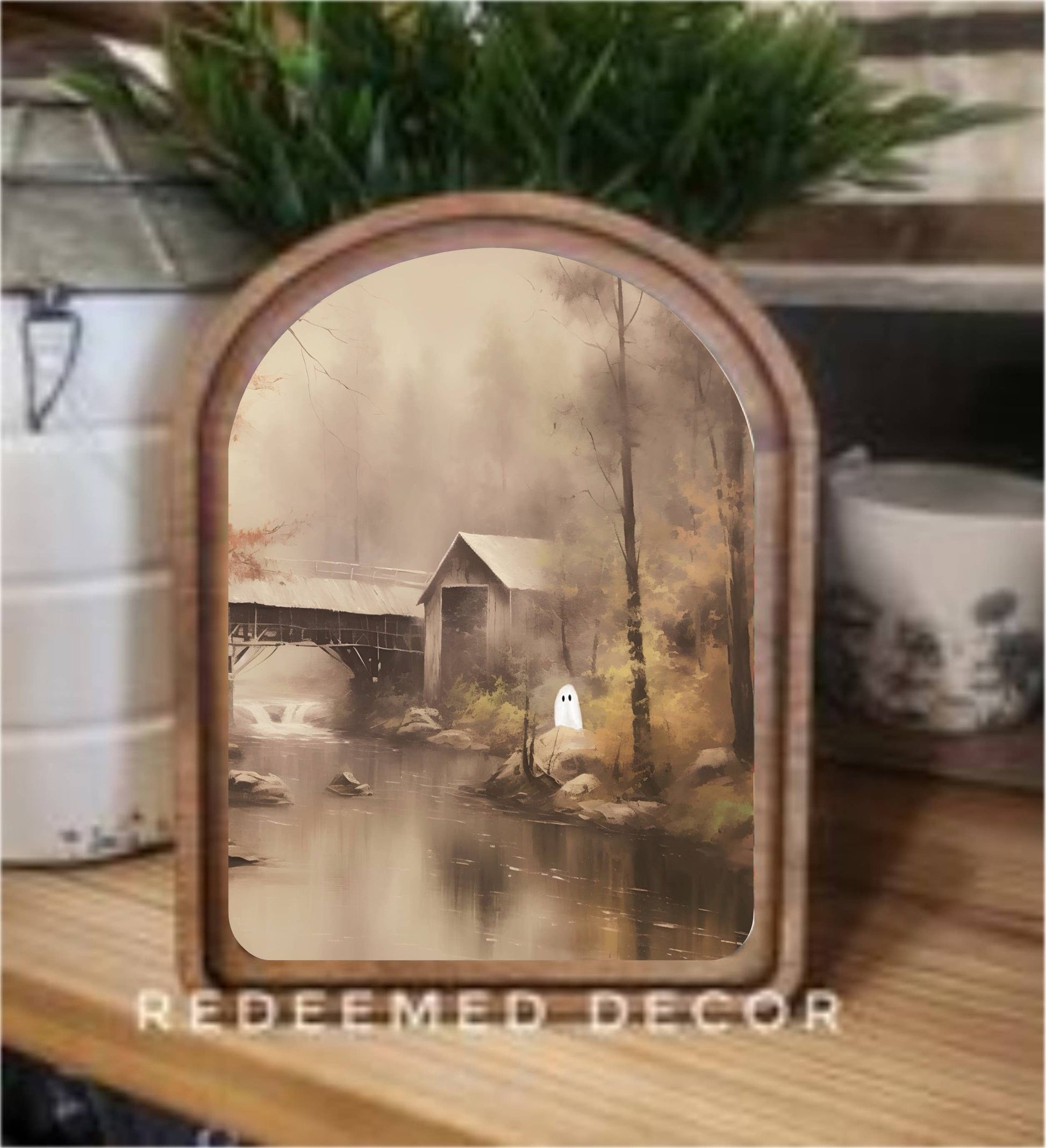 Arched wood-framed canvas art depicting misty riverside scene with ghost figure and covered bridge