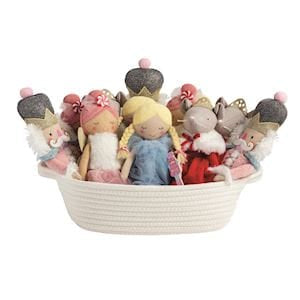 Assorted Nutcracker plush dolls in white rope basket, pink and blue holiday characters