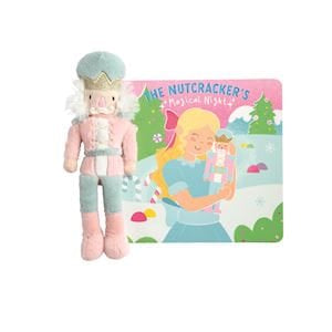 Pink nutcracker plush doll beside The Nutcracker's Magical Night hardcover storybook