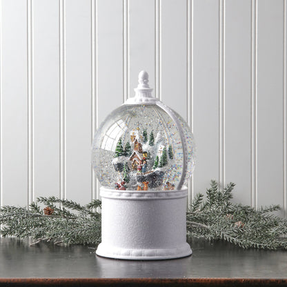 Large snow globe with winter village and Santa scene on white pedestal base, front view