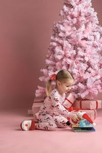Girl wearing red and white Christmas pajamas with Santa light-up slippers