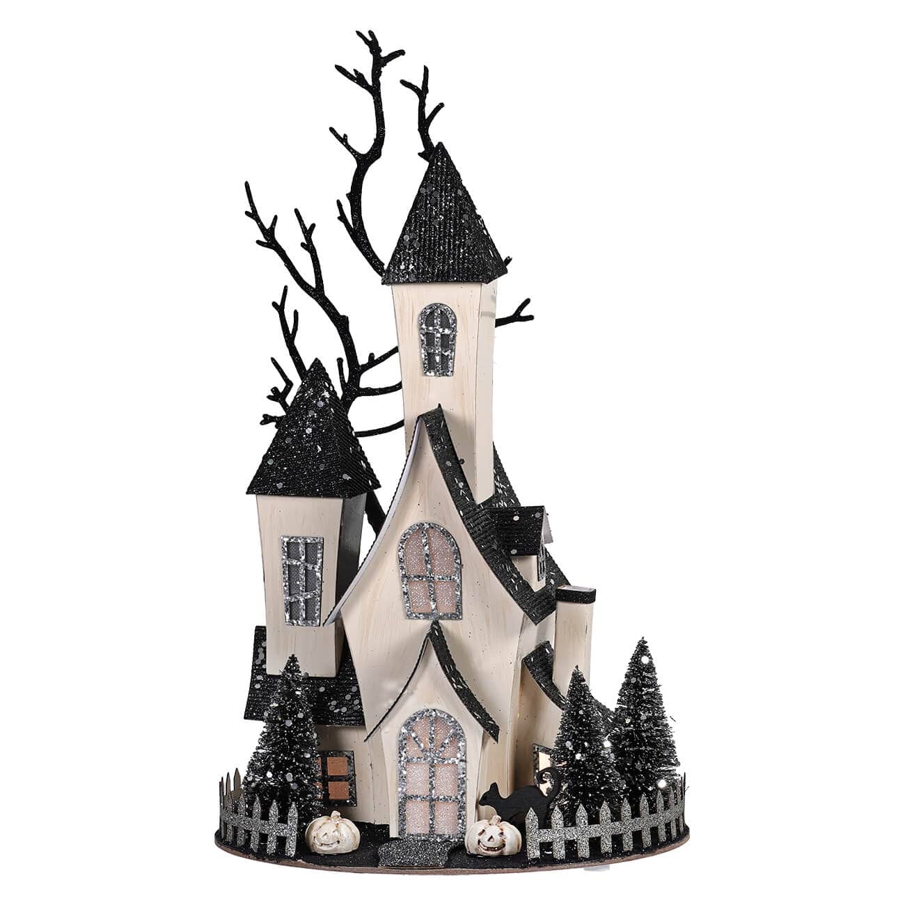 Cardboard haunted house decoration with black glitter roofs, bare trees, miniature pumpkins, and fence