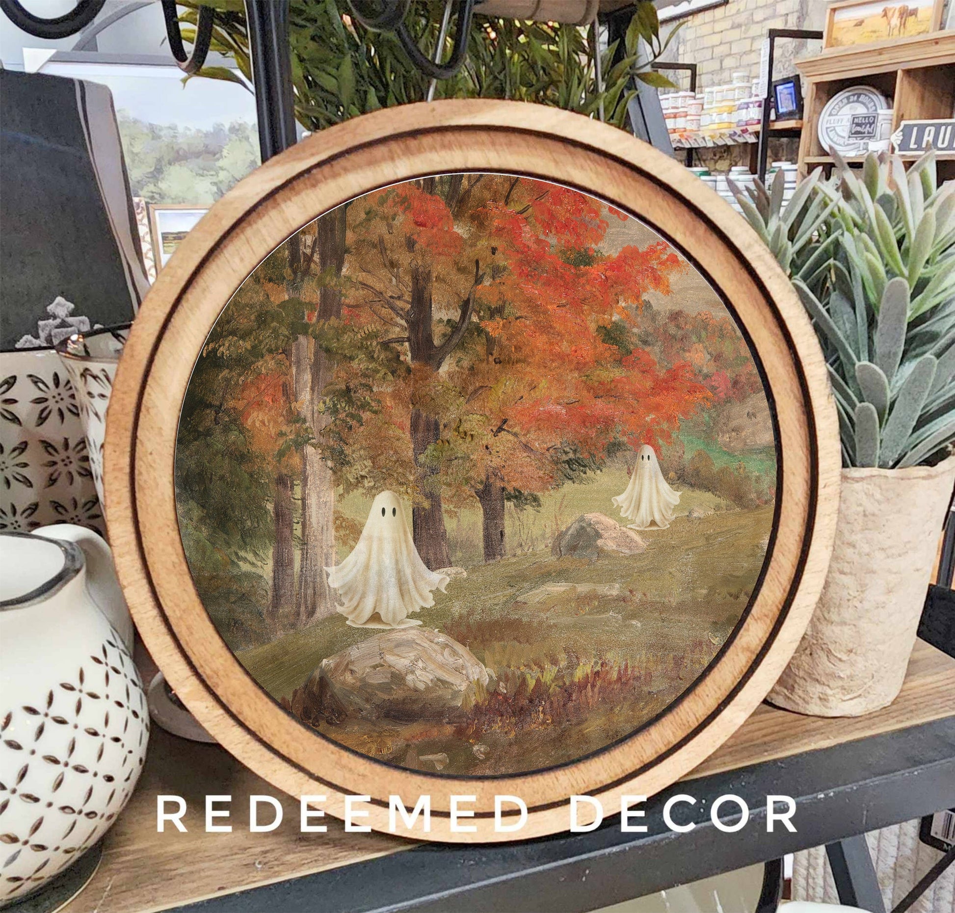 8-inch round wood-framed art print featuring ghost figures in autumn forest scene