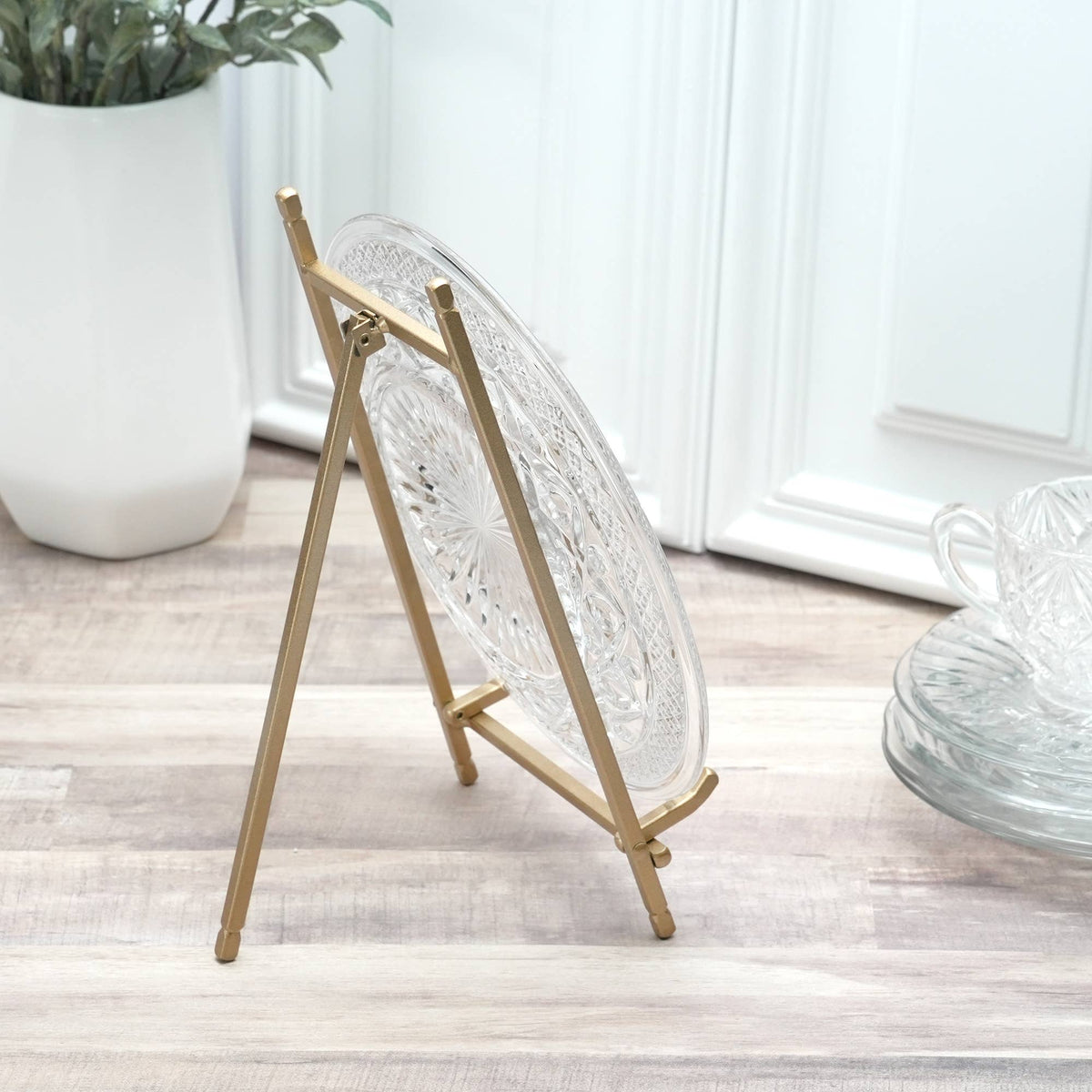 Gold satin metal easel stand displaying a clear cut glass decorative plate
