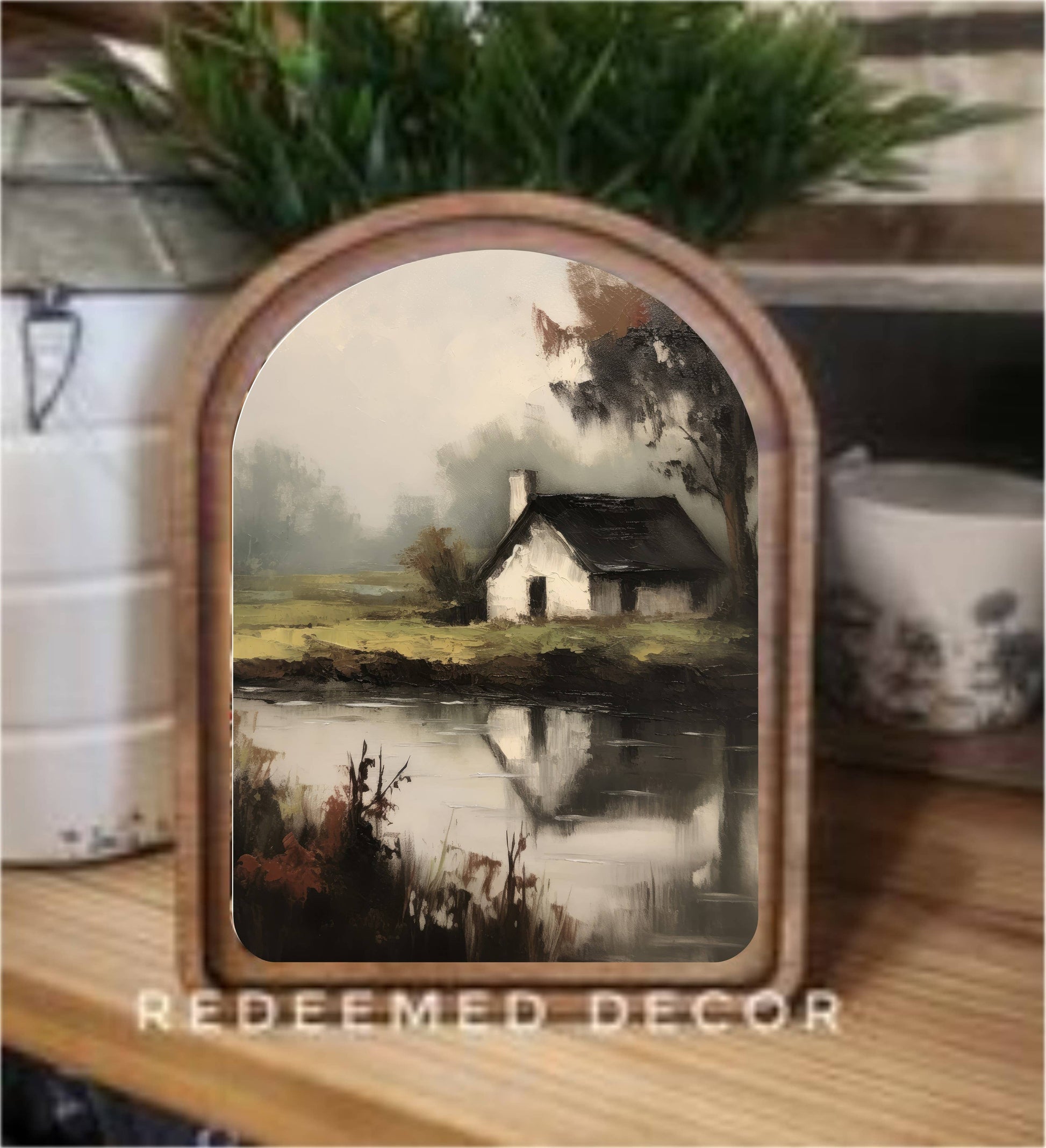 Arch-top wood framed canvas art of a misty cottage reflected in a pond