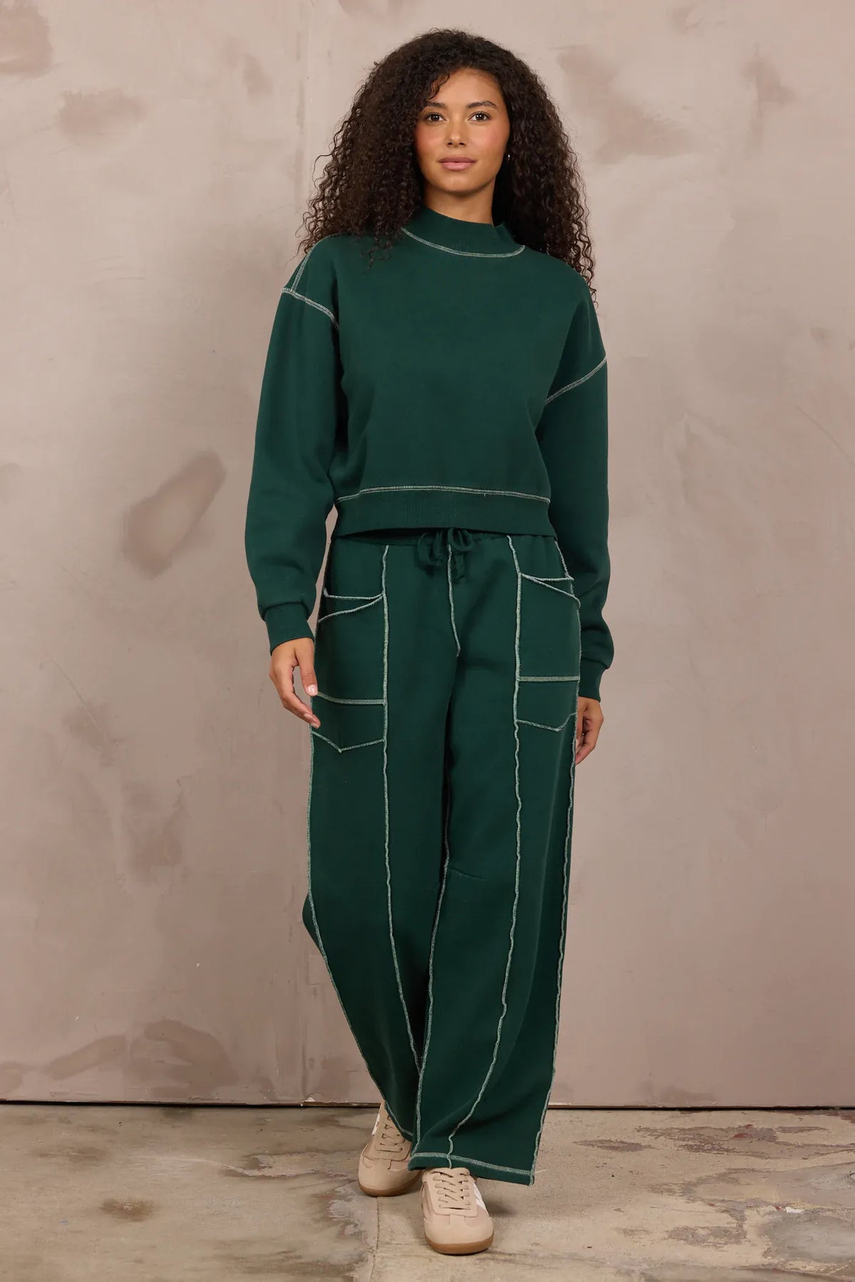 Forest green mockneck sweatshirt with contrast stitching, worn as matching set
