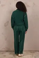 Green wide-leg barrel pants with white contrast stitching, back view