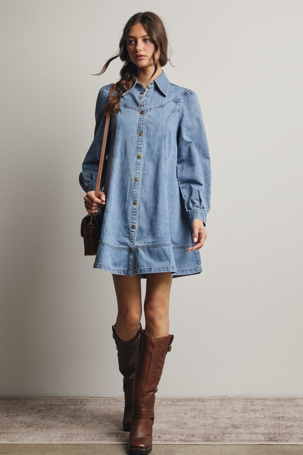 Light wash denim mini shirt dress with snap buttons, puff sleeves, and Western yoke detailing