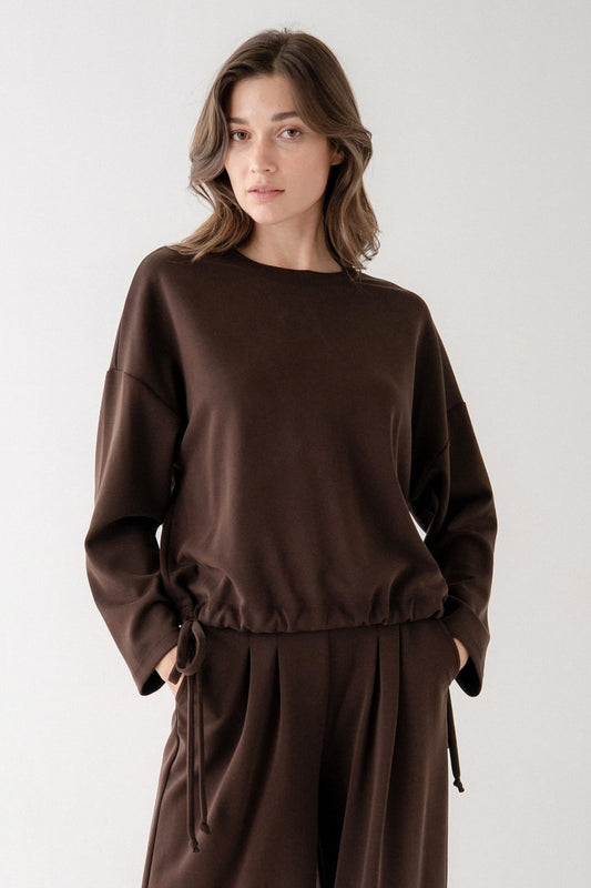 Women's dark brown long sleeve pullover top with drawstring hem and wide sleeves