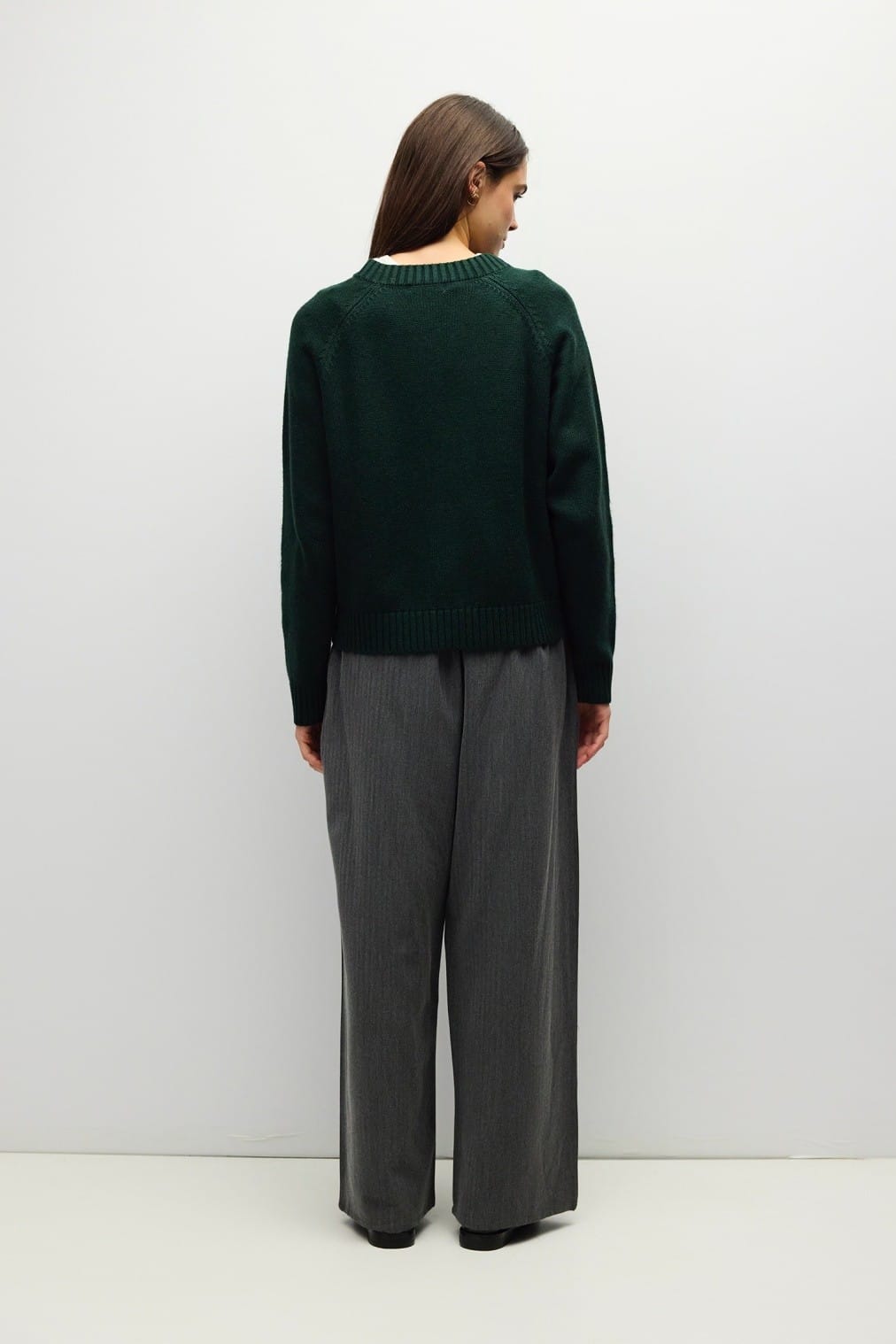 Dark green knit cardigan with raglan sleeves and ribbed hem, back view