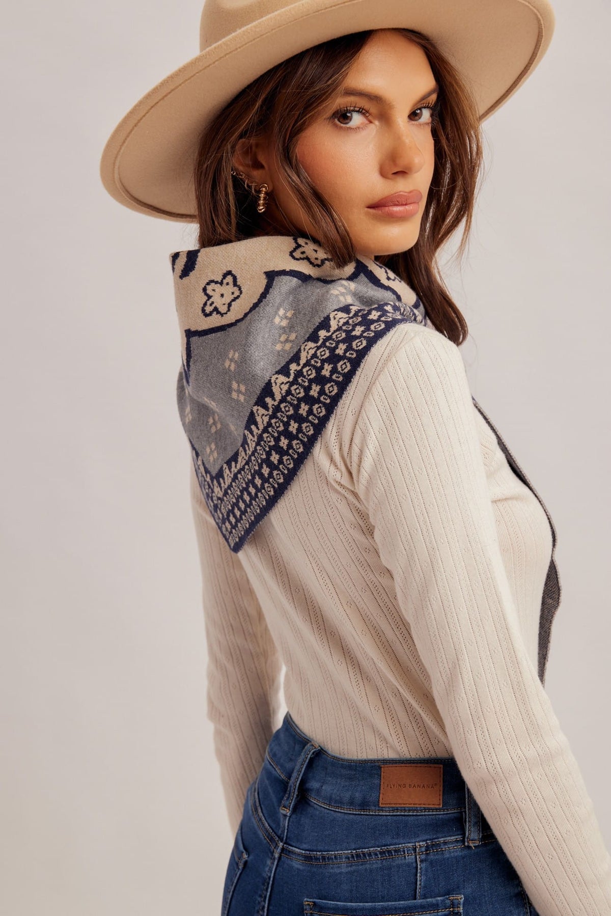 Navy and cream bandana-print triangle scarf with floral motif, styled around neck