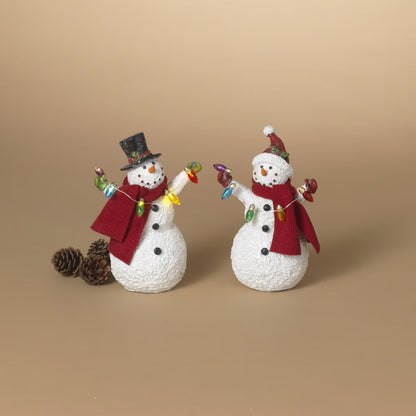 Two white resin snowman figurines with red scarves holding colorful Christmas light strings