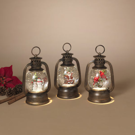 Three bronze lantern snow globes with snowman, Santa, and cardinal LED scenes