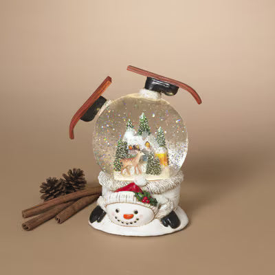 Lighted snowman snow globe with spinning winter scene, glitter, and skis on base