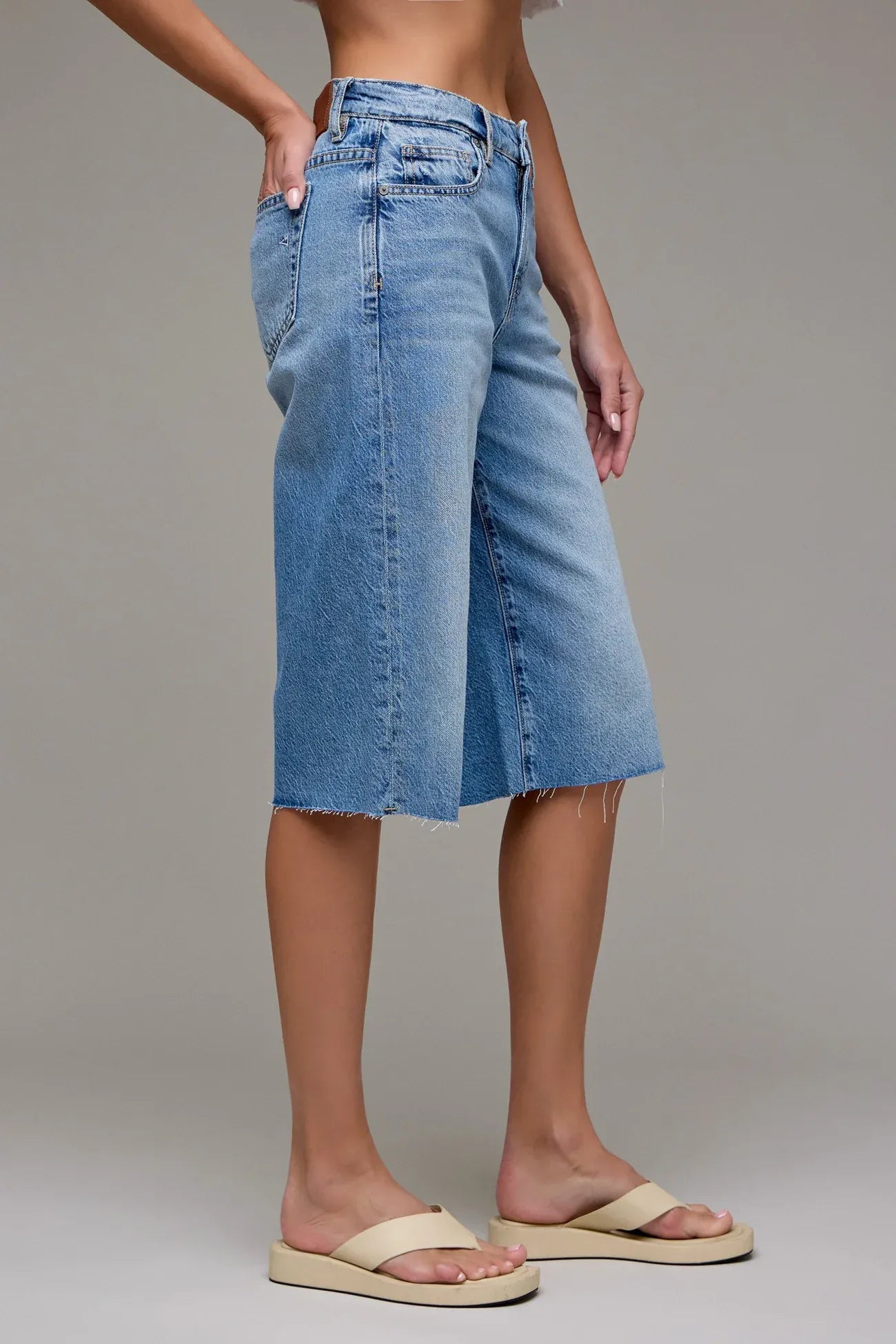 Light wash denim bermuda shorts with raw hem and wide leg, 14-inch inseam