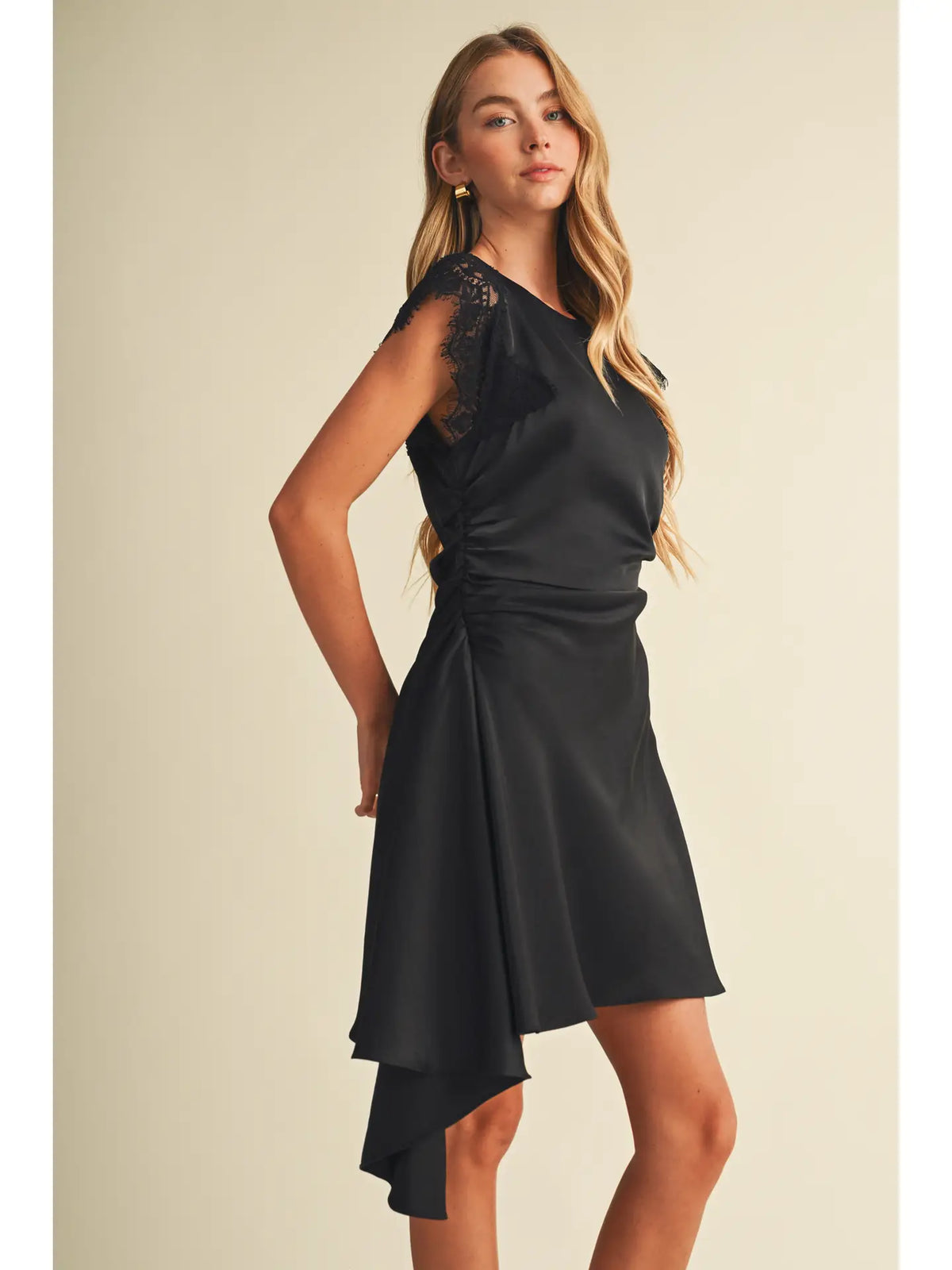 Black satin mini dress with lace cap sleeves, ruched waist, and asymmetric hem