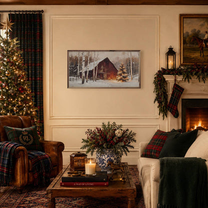 Framed winter barn painting with snow and lit Christmas tree, hung in cozy living room