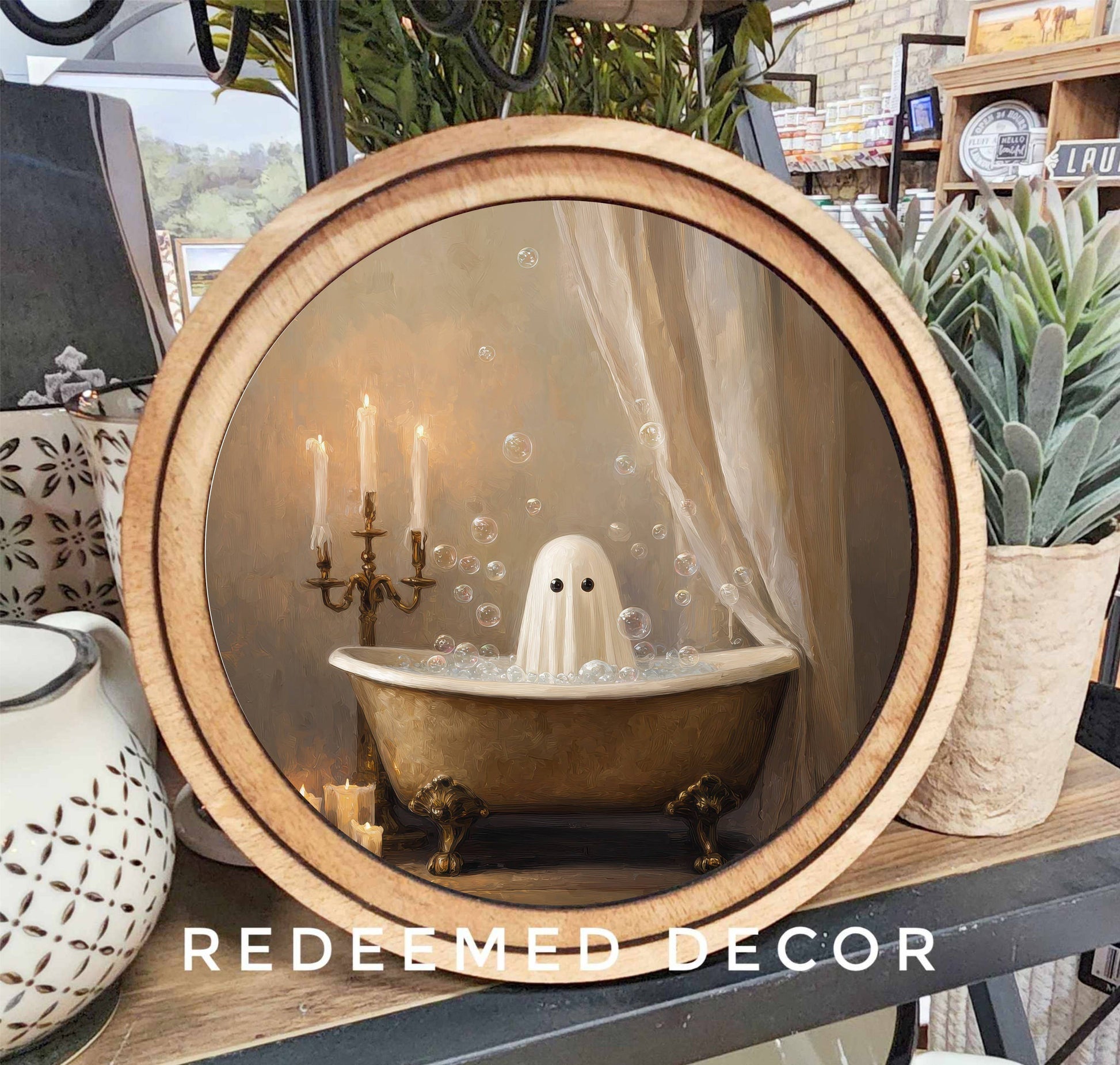 Round wood-framed canvas print of a ghost in a gold clawfoot bathtub with candles