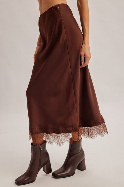 Chocolate brown satin midi skirt with lace hem trim, styled with dark brown boots