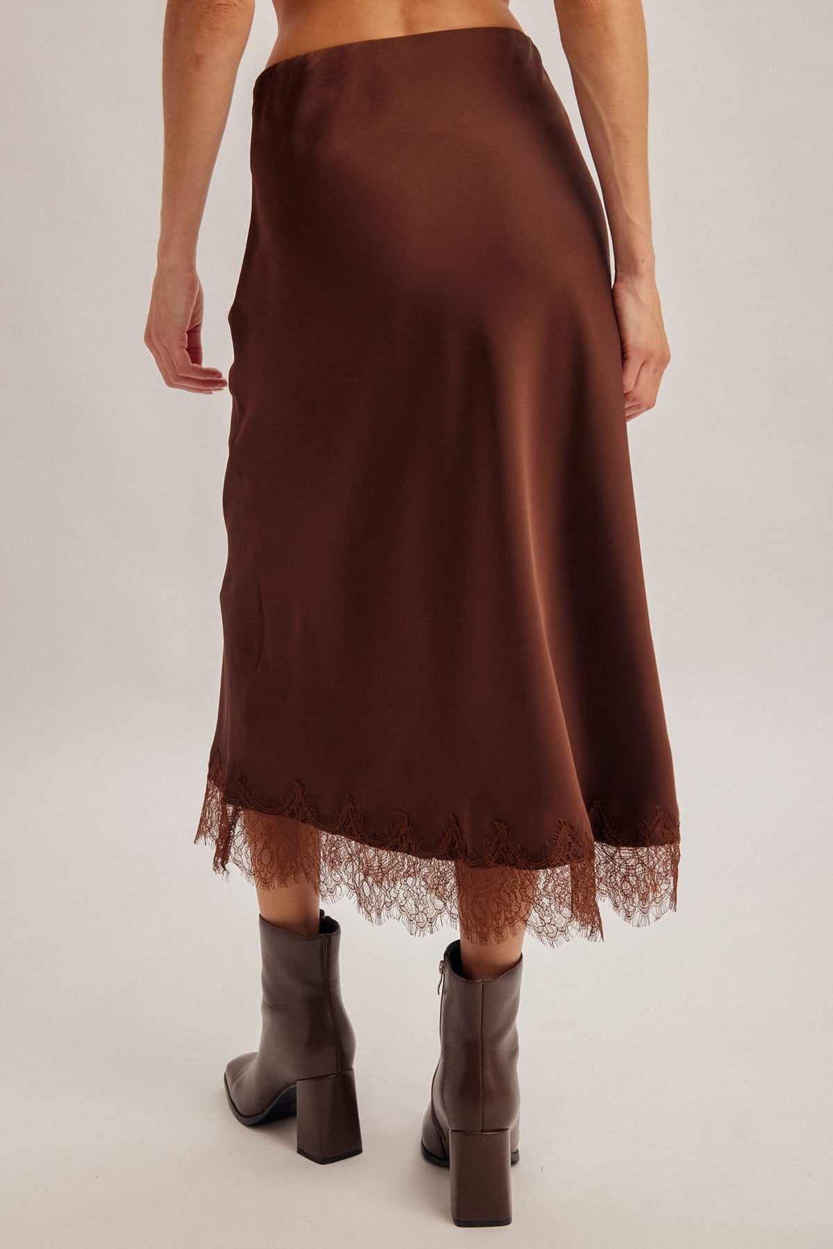 Chocolate brown satin midi skirt with lace hem trim, worn with brown boots