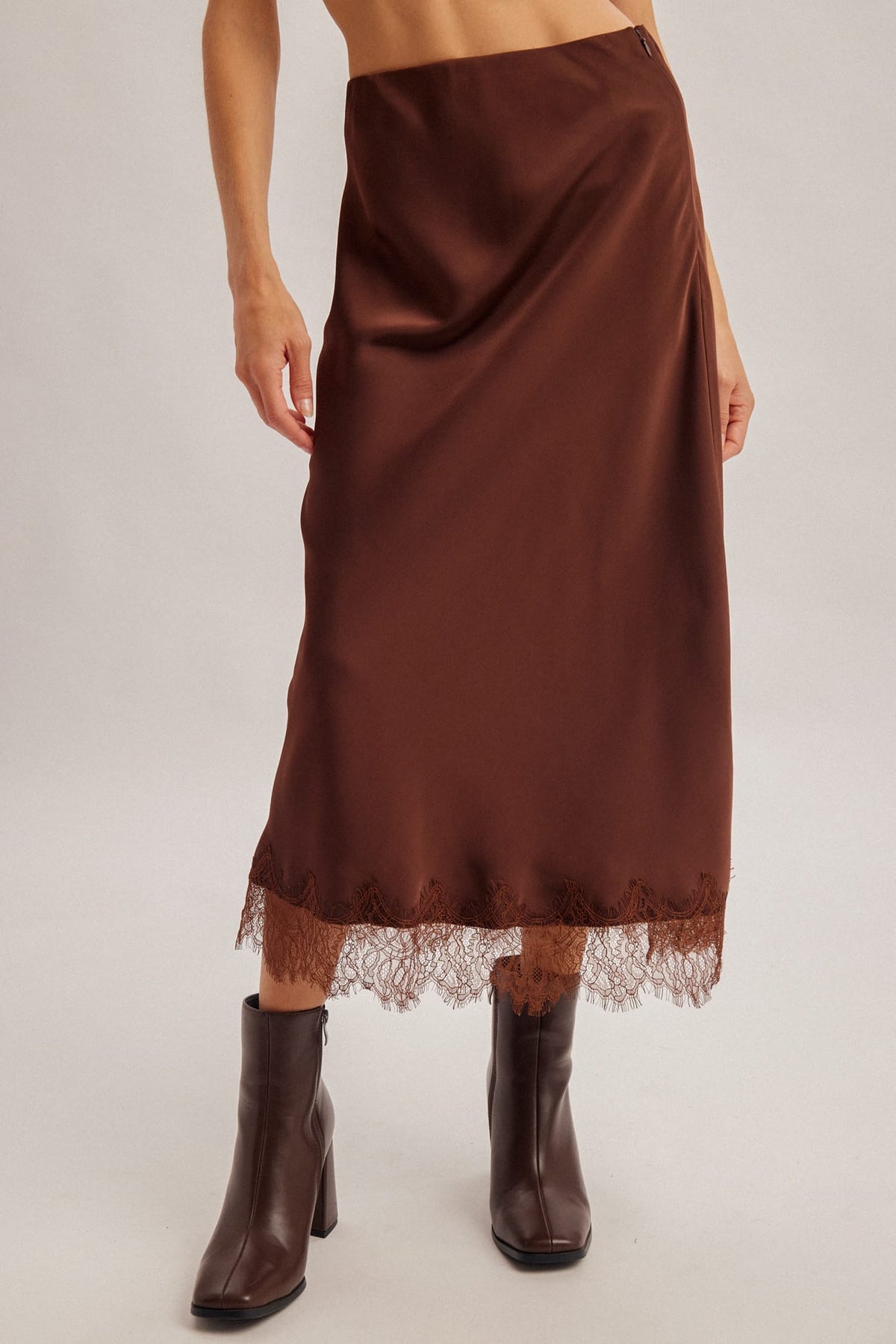 Chocolate brown satin midi skirt with lace hem trim, paired with dark brown ankle boots