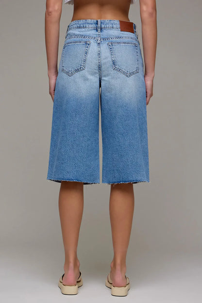 Light blue wide-leg denim bermuda shorts with raw hem, back view