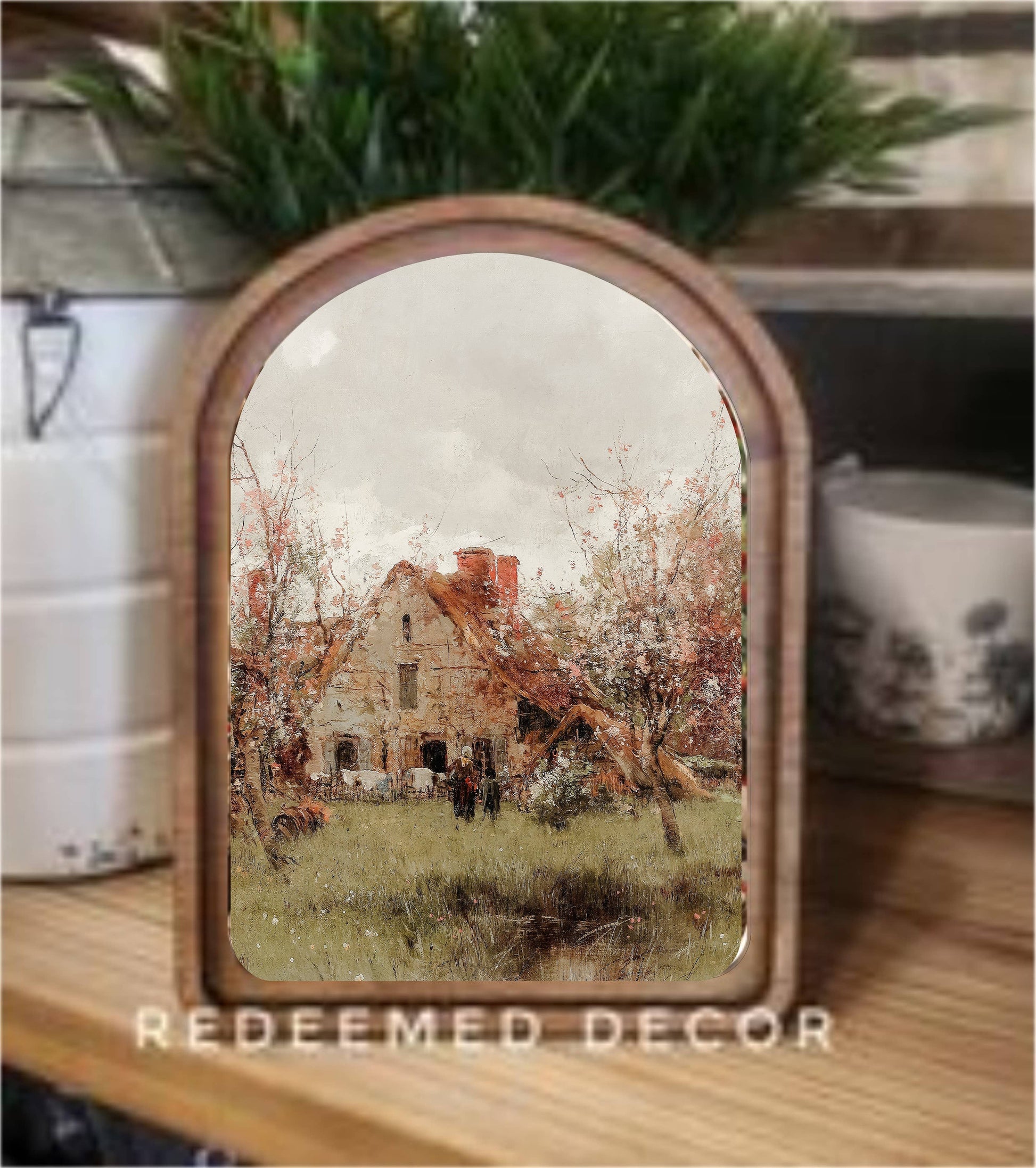 Arch top wood framed canvas art depicting a vintage French cottage with autumn trees