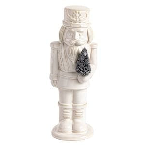 Large white ceramic nutcracker figurine holding a small decorative tree