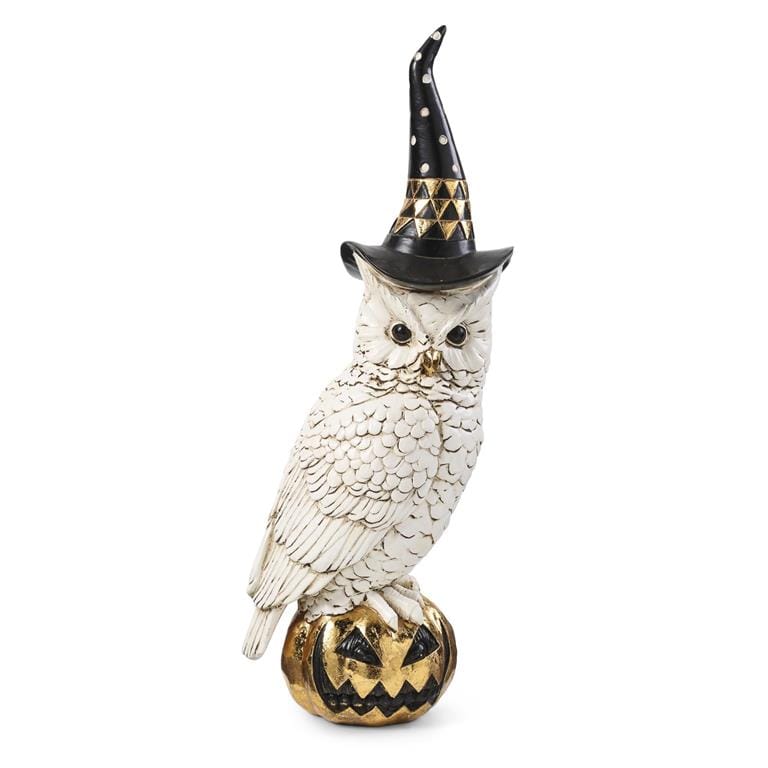 White resin owl figurine with black witch hat perched on gold jack-o-lantern