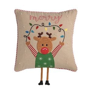 Beige holiday pillow with embroidered reindeer holding Christmas lights and dangling legs