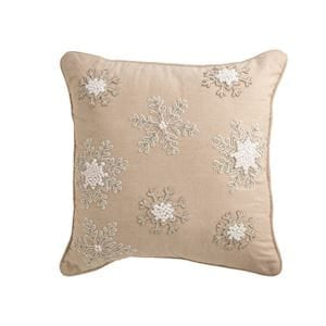 Tan square throw pillow with embroidered white beaded snowflake pattern