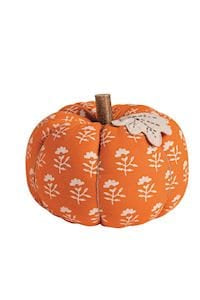 Orange fabric stuffed pumpkin with white floral block print pattern and twig stem