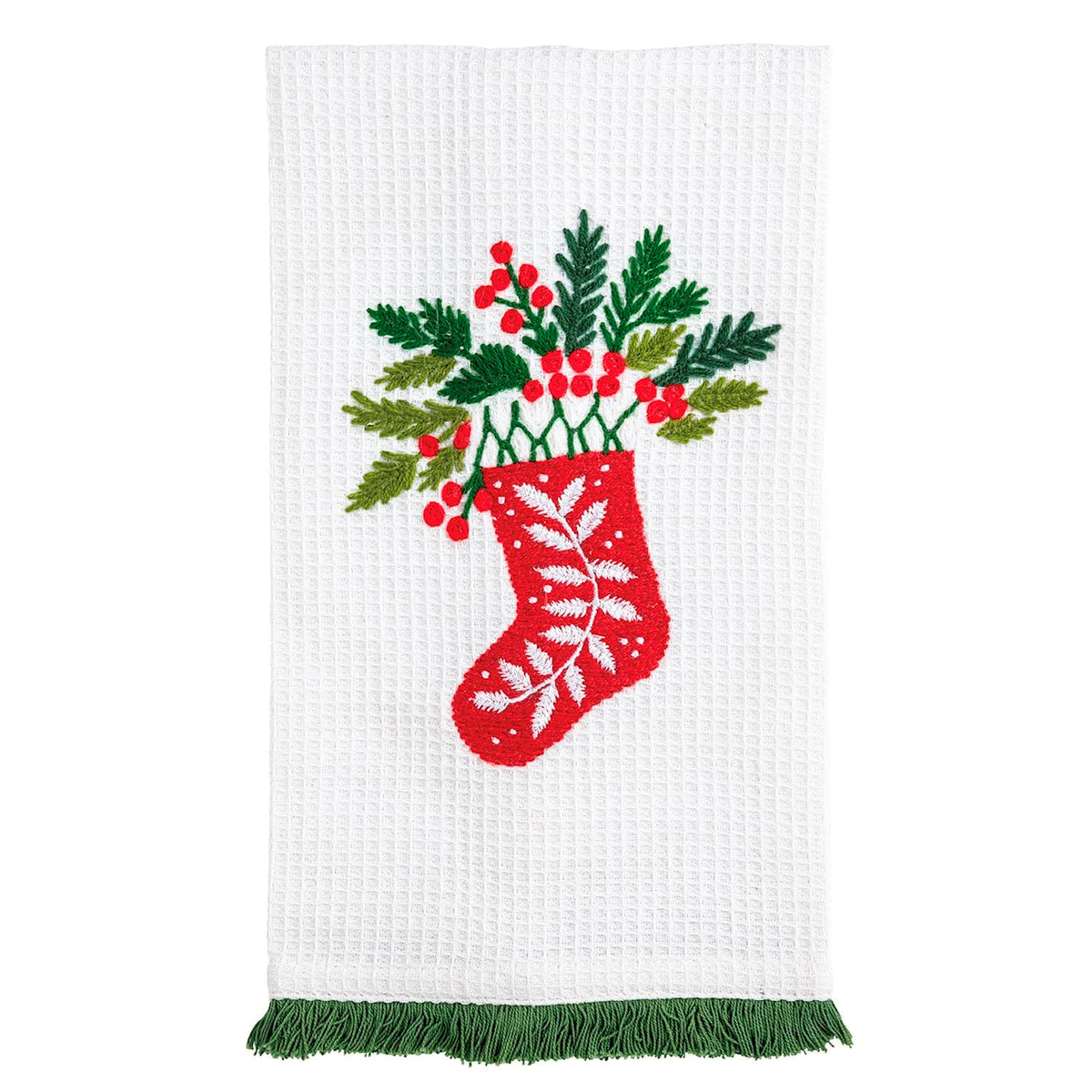 White waffle kitchen towel with embroidered Christmas stocking, holly, and green fringe trim