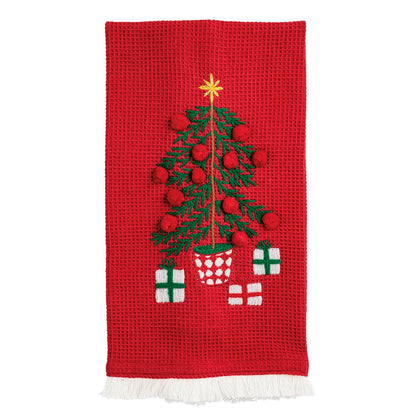 Red waffle weave kitchen towel with embroidered Christmas tree, pom-poms, and fringe