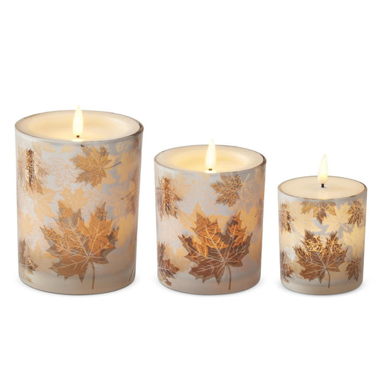 Three frosted glass LED candles with gold maple leaf pattern in graduated sizes