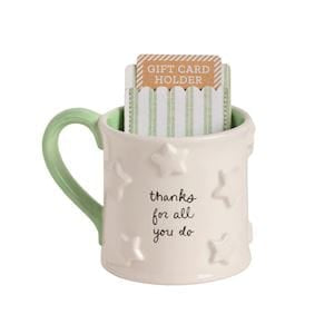 Cream ceramic mug with green handle and stars, holding a striped gift card sleeve