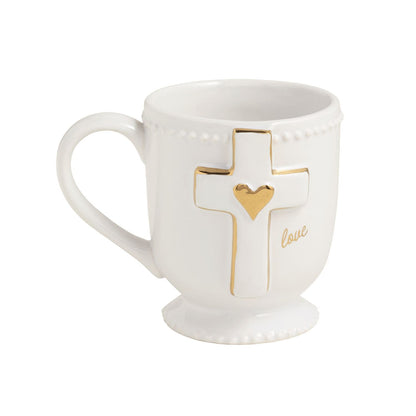 White ceramic footed mug with gold cross, heart, and 'love' script detail