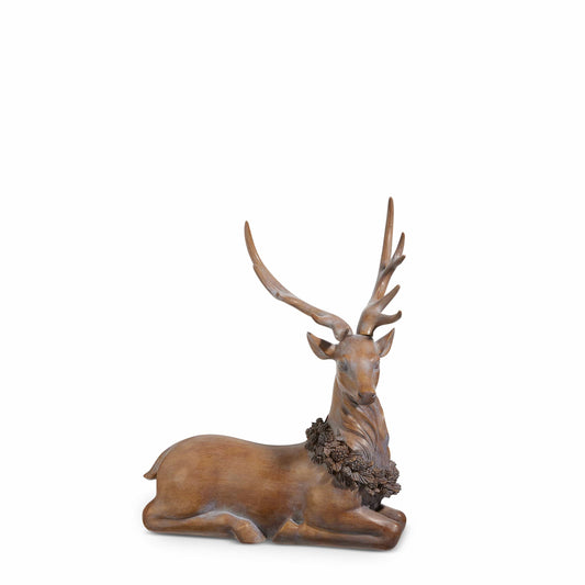Resin laying stag figurine with large antlers and decorative pinecone holly wreath around neck