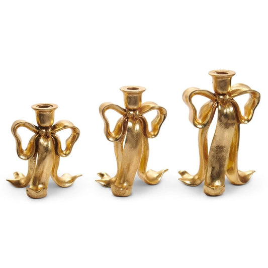 Set of three gold bow-shaped taper candlestick holders in graduated sizes