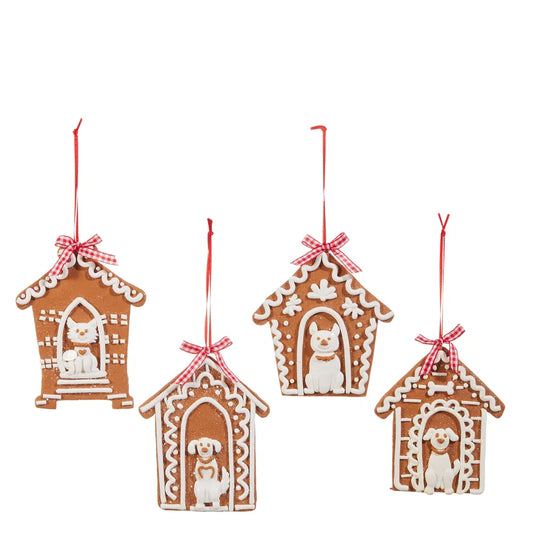 Four gingerbread doghouse Christmas ornaments with white icing and red ribbon bows