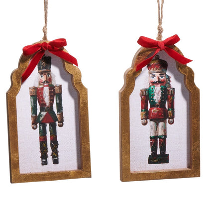 Two gold-framed nutcracker ornaments with red bows and twine hangers, sold separately