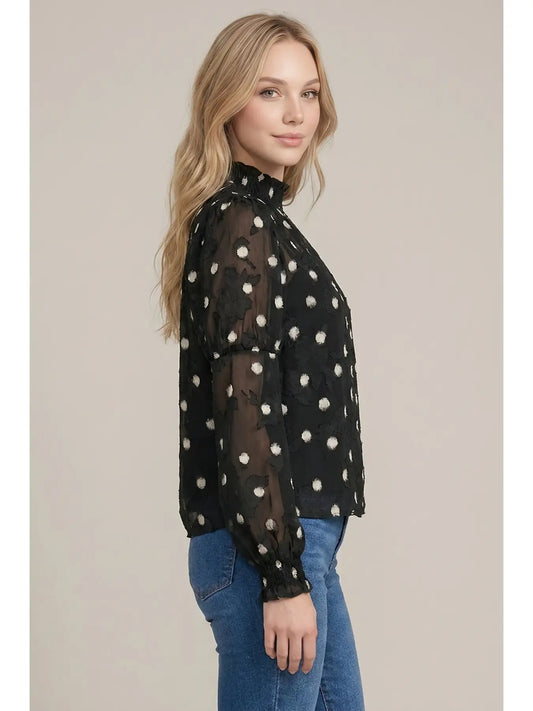 Black sheer polka dot mock neck blouse with puff sleeves and smocked cuffs