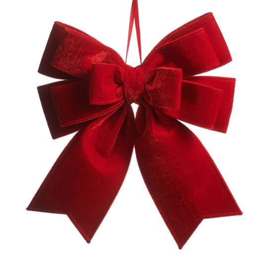 Large velvet decorative bow ornament with multiple loops and tails, hanging on ribbon