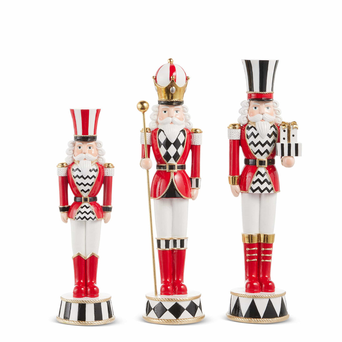 Set of three decorative nutcracker figurines in red, white, and black with top hats and royal accessories