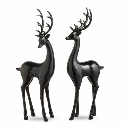 Pair of glossy black deer figurines with antlers standing upright, facing each other