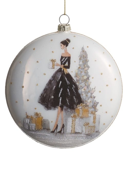 Glass disc ornament featuring elegant woman in black gown with Christmas tree and gifts