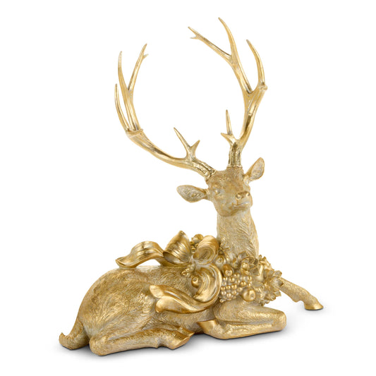 Gold resin laying deer figurine with large antlers and decorative bow and floral accents