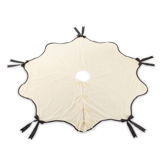 Round scallop-edged tree skirt in cream velvet with black satin ribbon bows and center lace-up closure